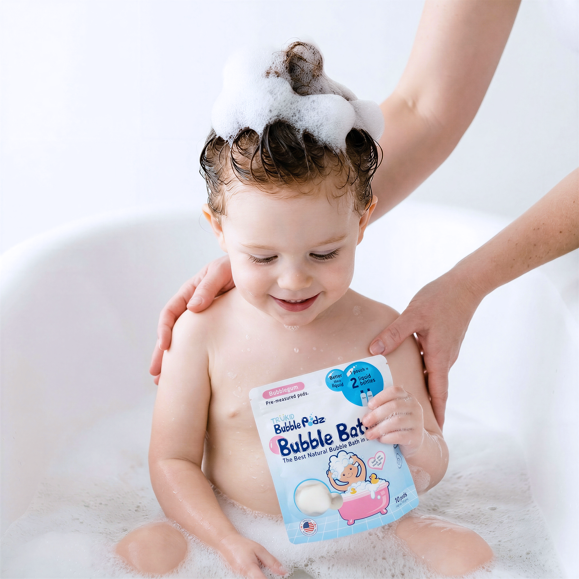 Child in a bathtub with bubbles, holding a Bubble Bat product packaging.