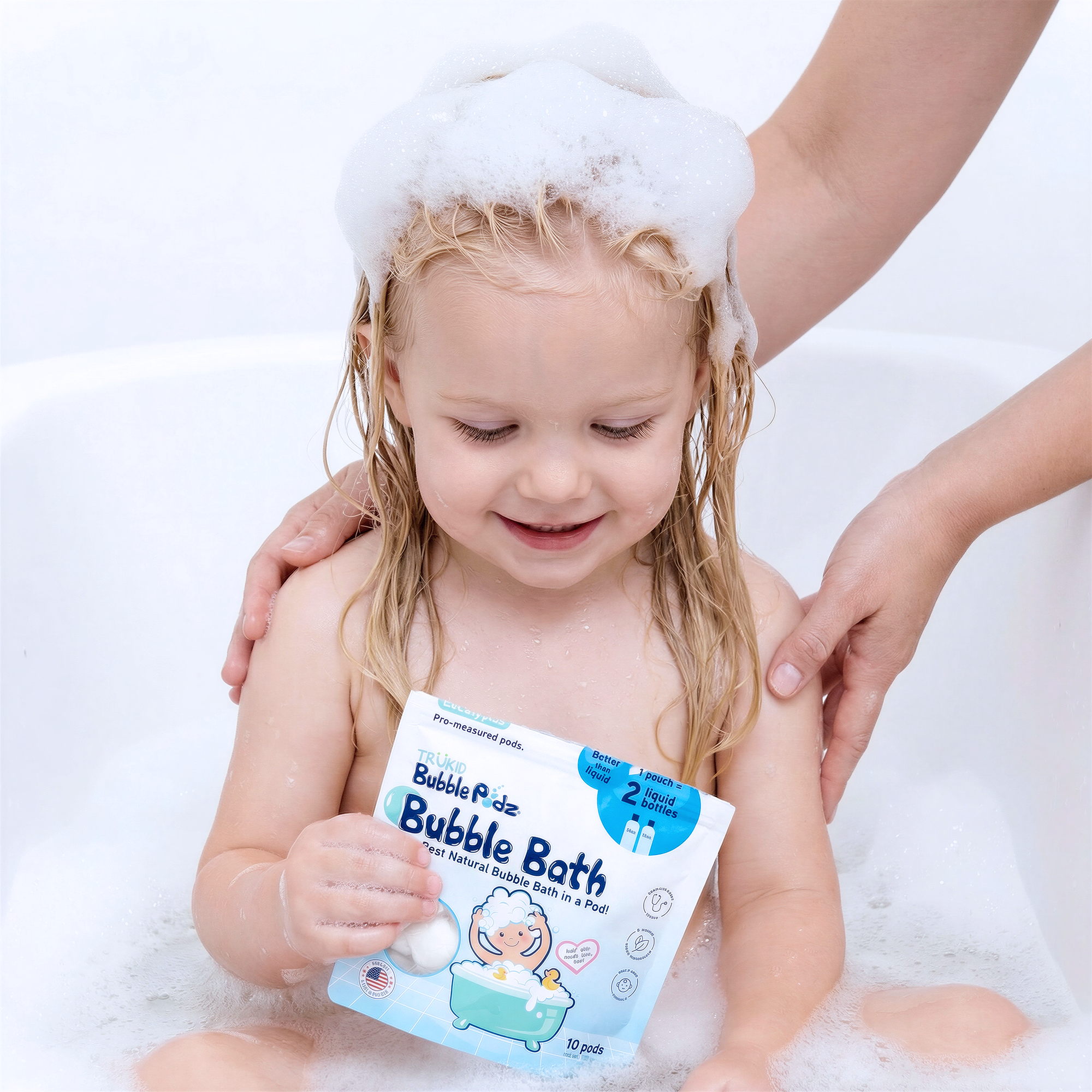Child in a bubble bath holding a package of TruKid Bubble Bath podz.