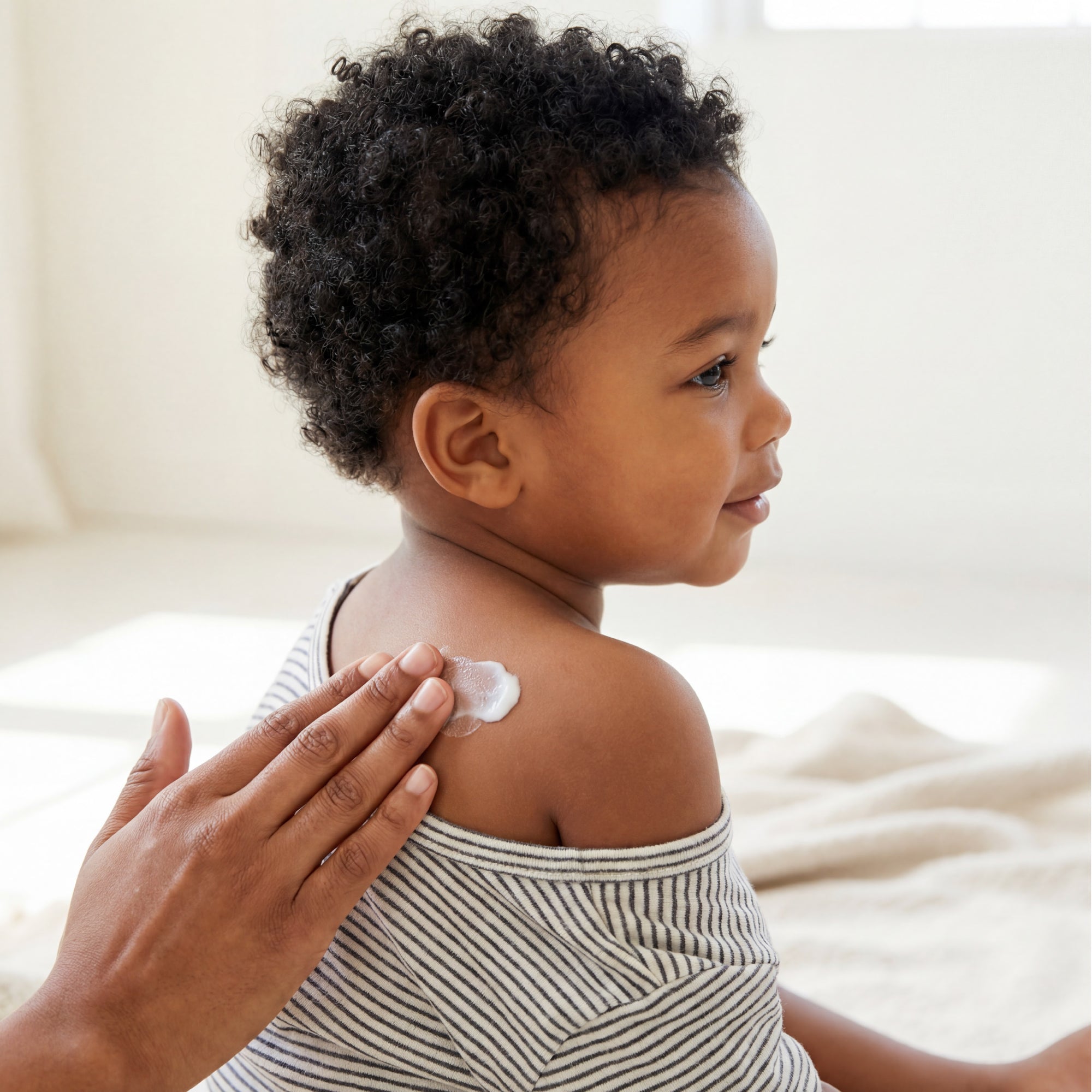 Child with a small patch of cream on their shoulder, with a blurred background
