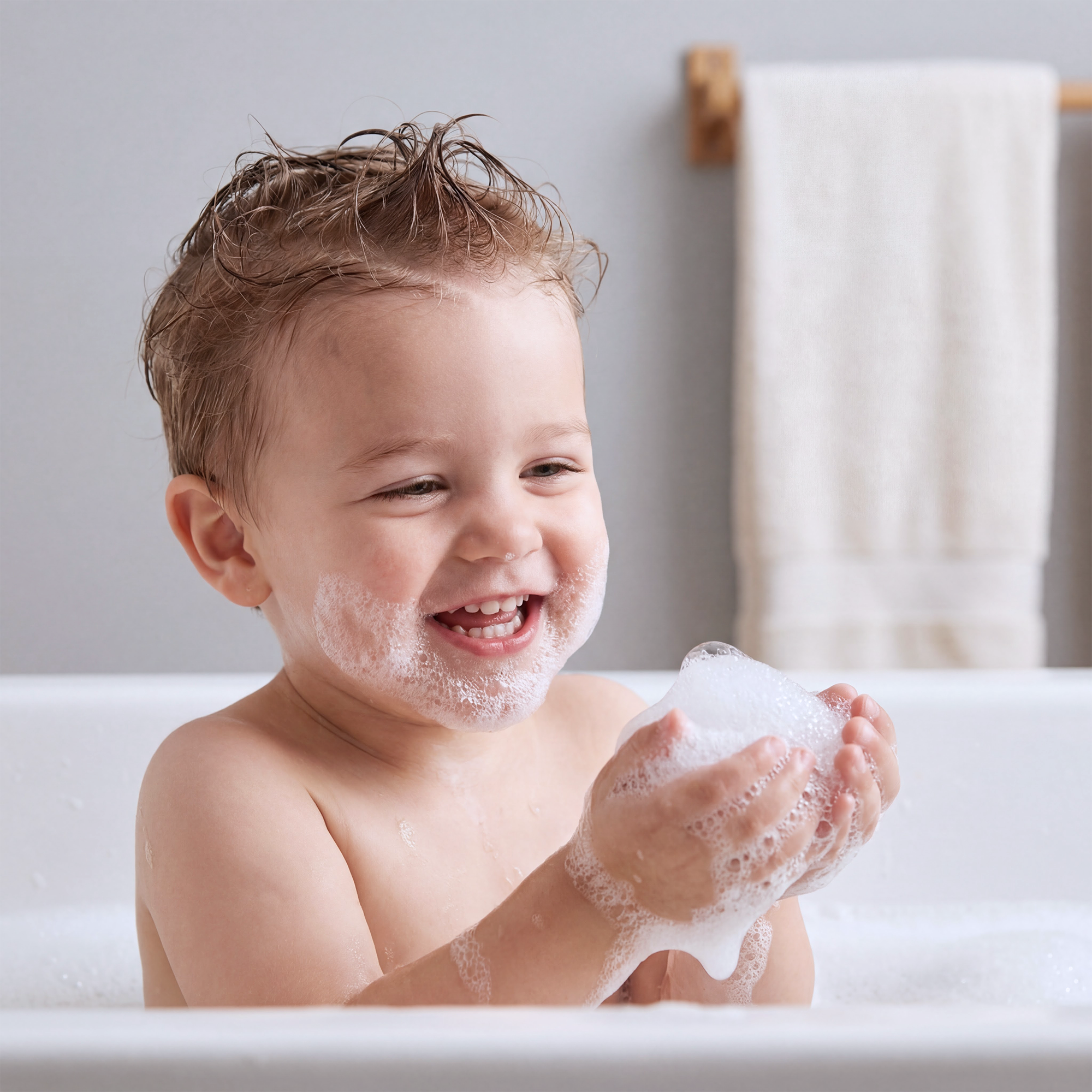 Child playing with soap bubbles in a bathtub