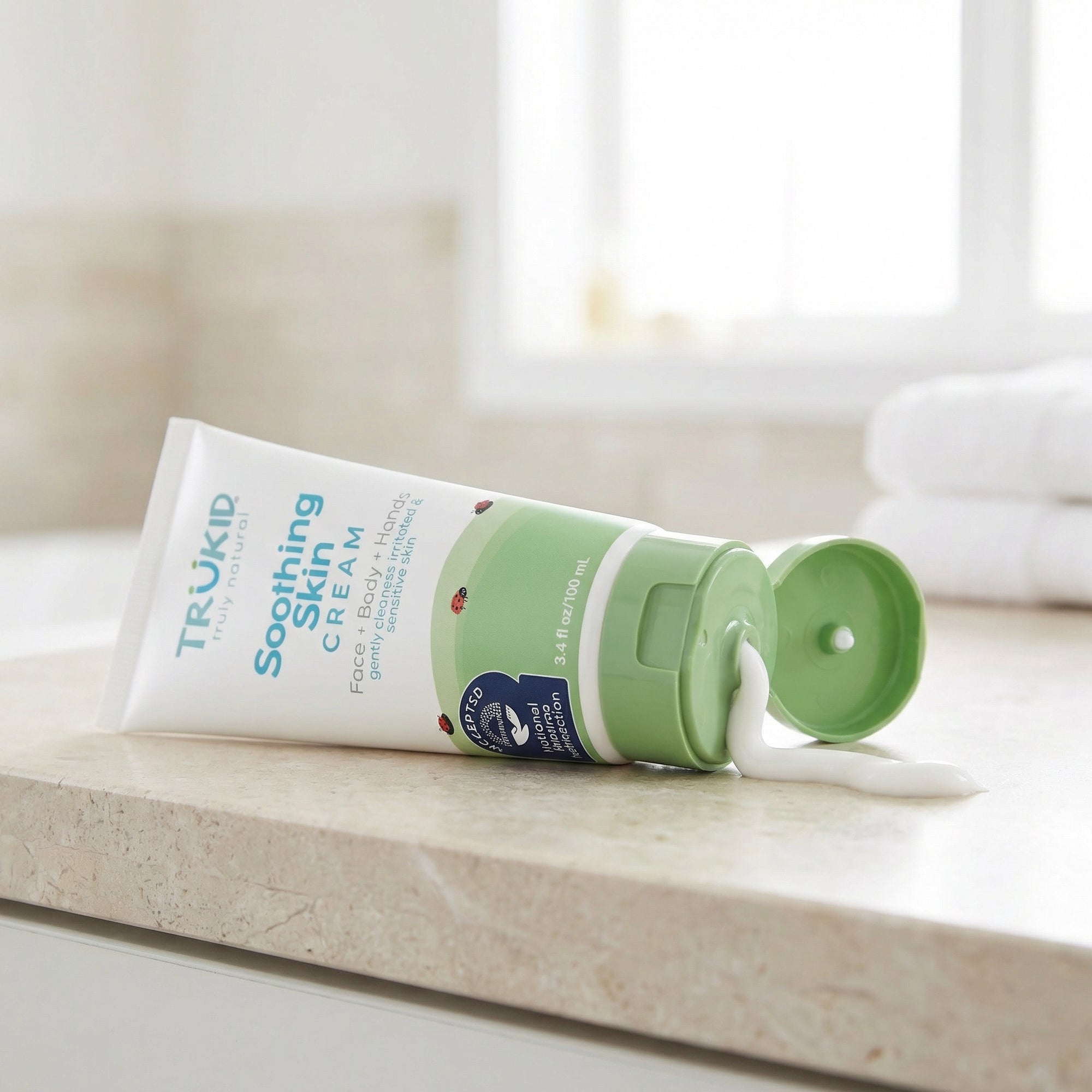 Trukid Soothing Skin Cream tube on a wooden surface with a blurred background