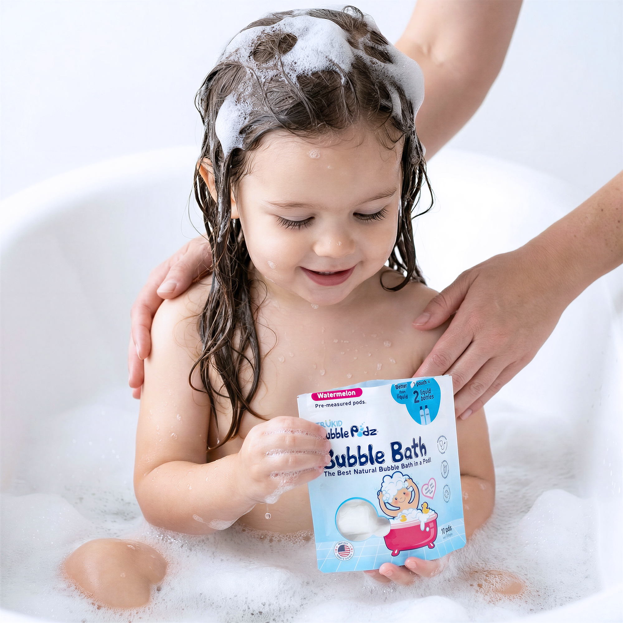 Child in a bathtub with bubble bath packaging, surrounded by bubbles